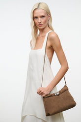 Husk brown cuff clutch with silver snap top held by model