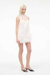 White sleeveless mini dress with feather trim hem and round neckline