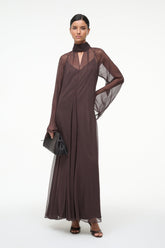 Brown maxi dress with high neck scarf, sheer sleeves, and side drape detail
