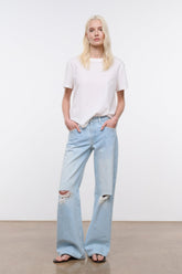 Light blue distressed relaxed jeans, wide leg silhouette with ripped knee panels