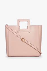 Blush leather tote bag with crossbody strap and gold buckle hardware
