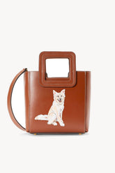 Tan mini leather bag with dog photo front and adjustable crossbody strap.