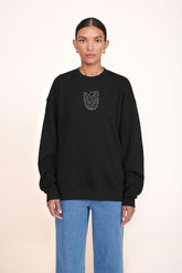 Black oversized crewneck sweatshirt with small embroidered animal graphic at center