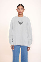 Grey oversized sweatshirt with small chest graphic, crewneck long sleeves