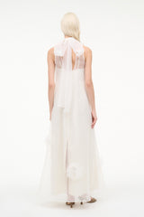 White sleeveless long dress, open back with feather-trim accents along panels
