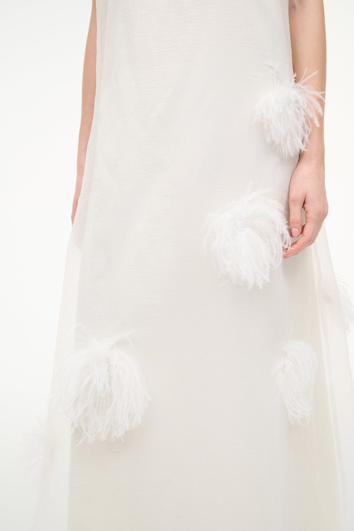 White sleeveless maxi dress with feather pom-pom details on front and hem