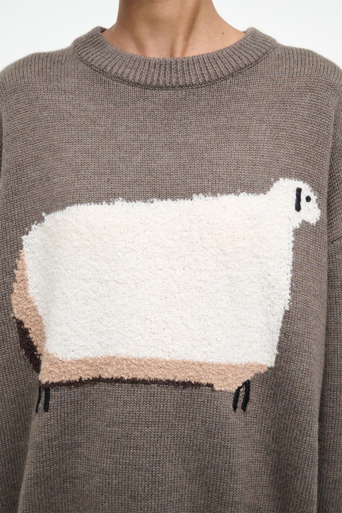 Taupe sweater with oversized white sheep graphic and ribbed crew neckline