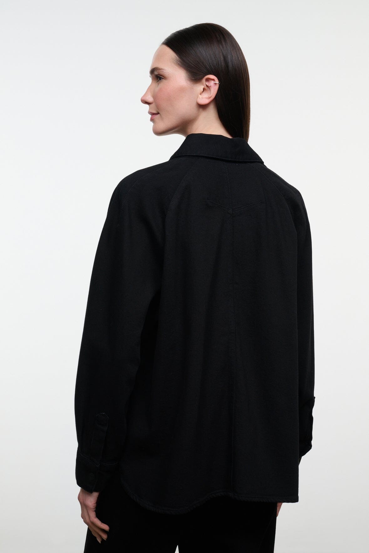 Black shirt jacket with stand collar and button front, long sleeves; back view.