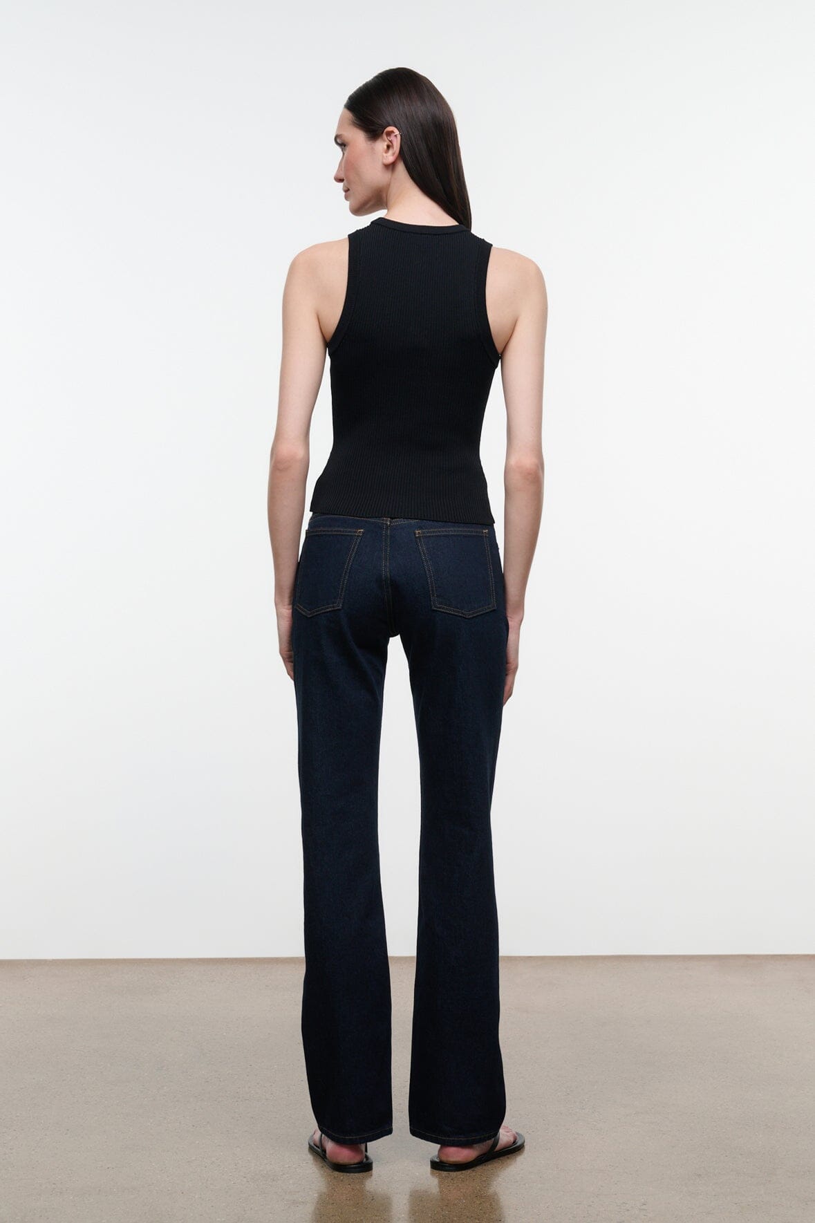 Straight-leg indigo jeans shown from the back with patch pockets and belt-loop waistband