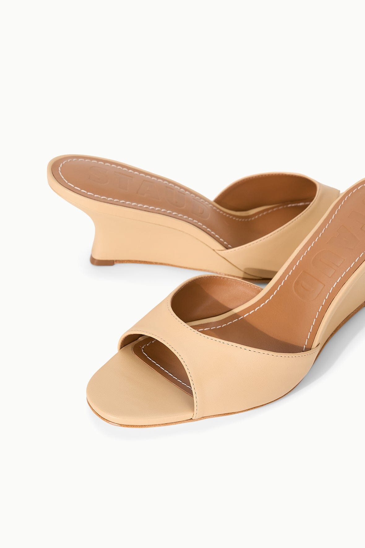 Tan wedge sandals with stitched upper, open toe, and low heel